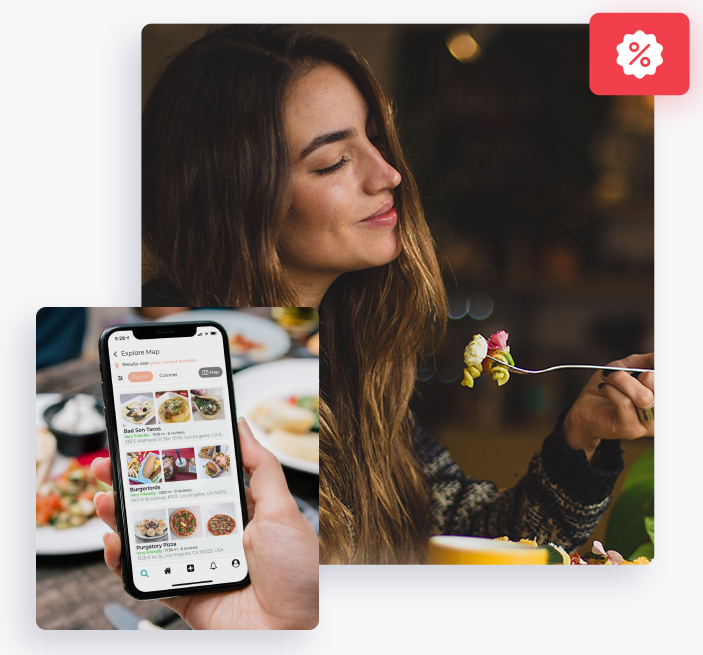 A woman is looking at her smartphone displaying a food app while holding a fork with a bite of food, with a discount tag icon in the corner suggesting a deal or promotion.